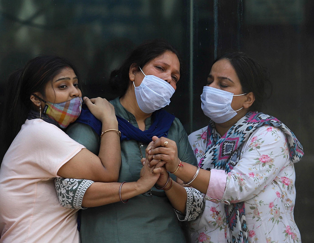 At a crematorium in New Delhi, India, women mourn a person who died of COVID‑19. Photo by Vijay Pandey/ZUMA Wire/Alamy